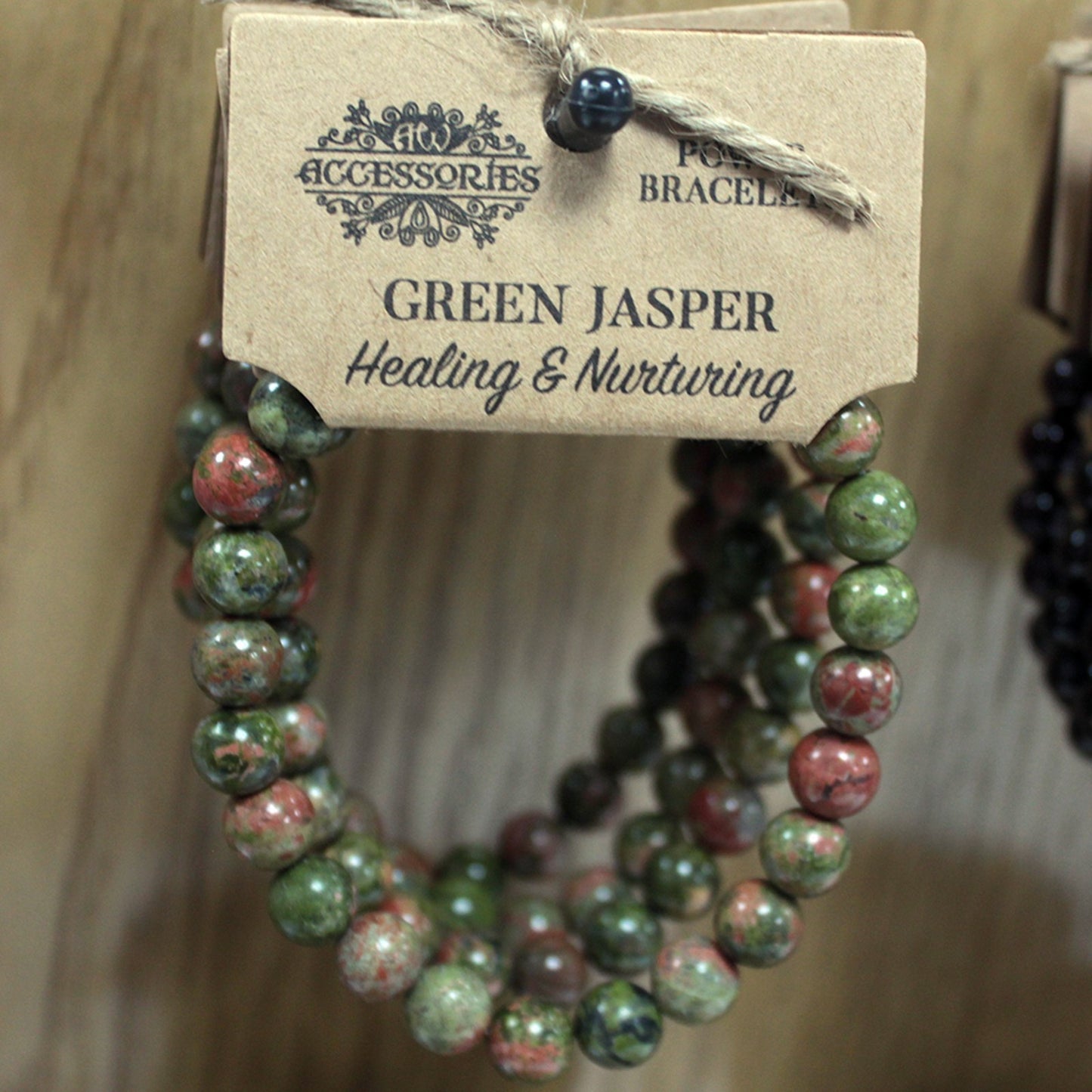 Pulsera brazalete de piedras verdosas de jaspe verde con etiqueta de cartón colgado en expositor
