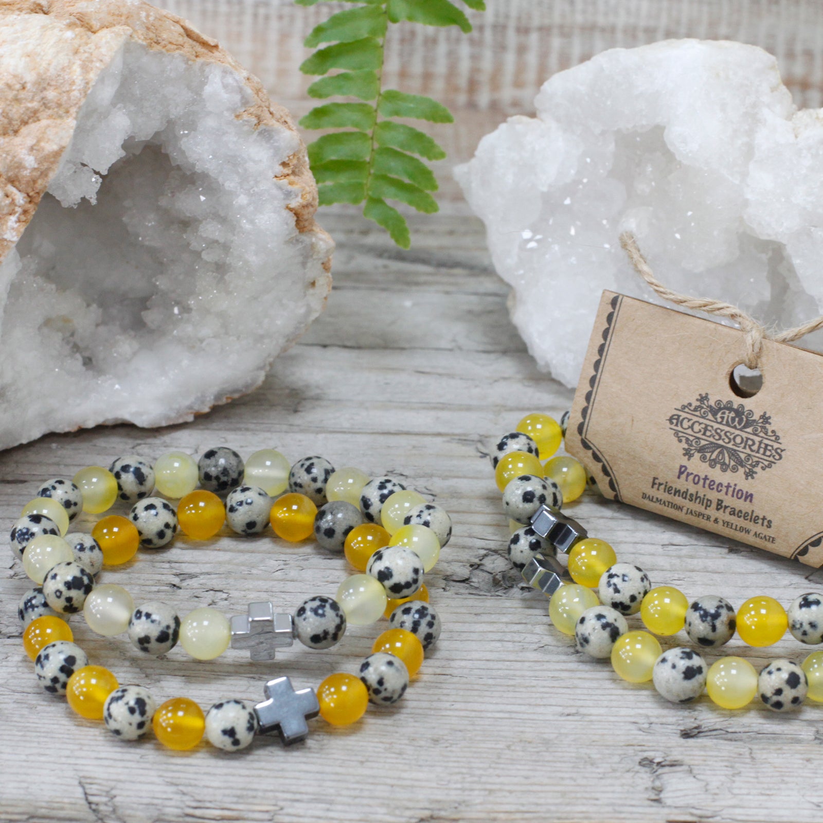 Varias pulseras de piedras amarillas y blanco dálmata presentada junto a geodas blancas