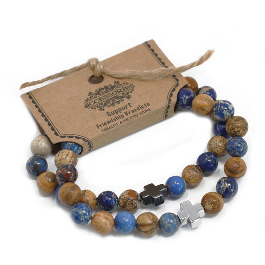Dos pulseras de piedras preciosas marrones y azules con una cruz plateada en soporte de cartón para colgar en expositor