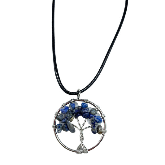 Collar con dije en forma de árbol de la vida plateado adornado con piedras azuladas de sodalita que simulan ser las hojas